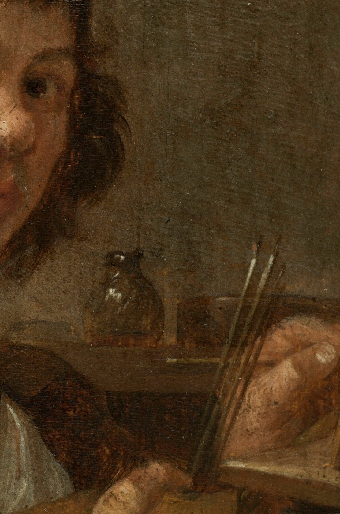 He's showing you the tools that make the painting exist.