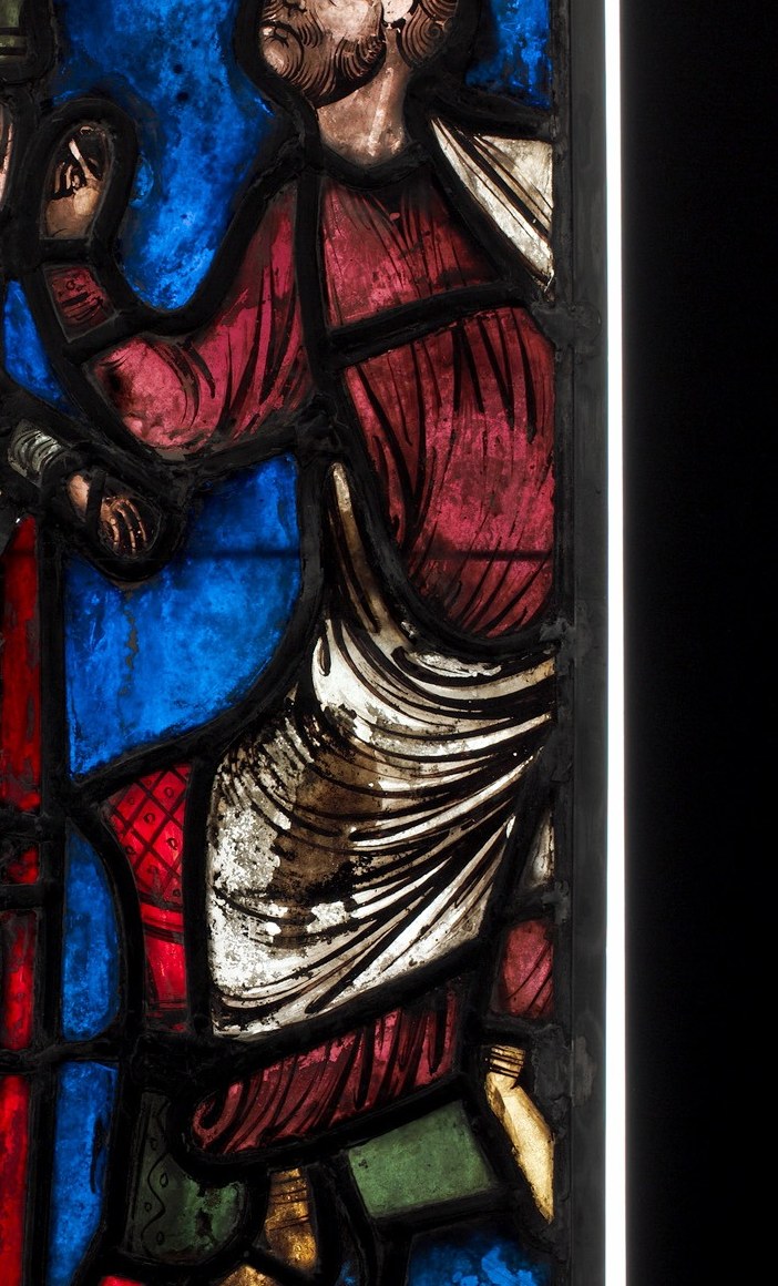 The saturated red garment signals authority and guilt simultaneously , red in medieval stained glass iconography often denotes power or blood.