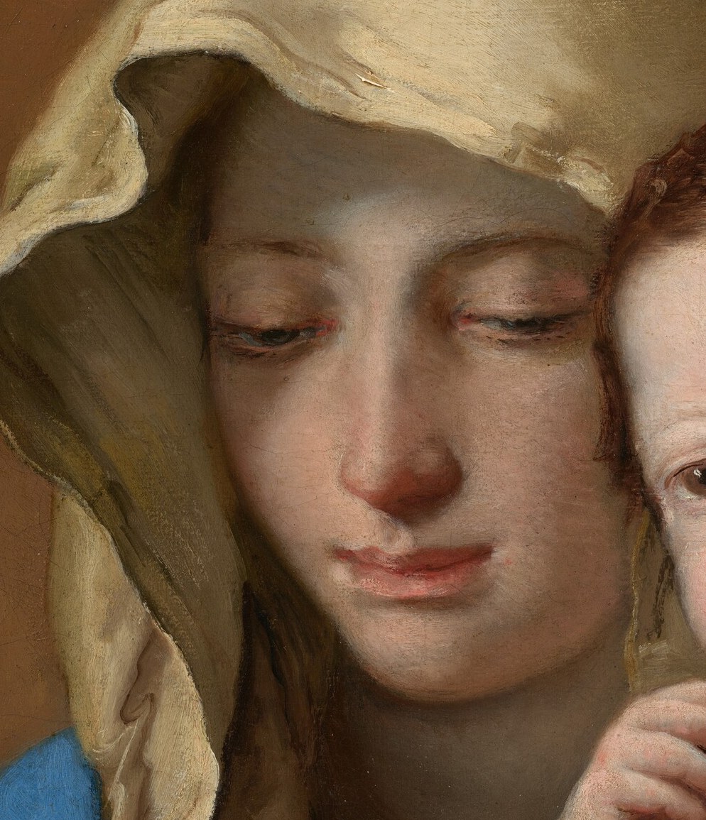 Her face shows a maternal tenderness, and a hint of sadness.