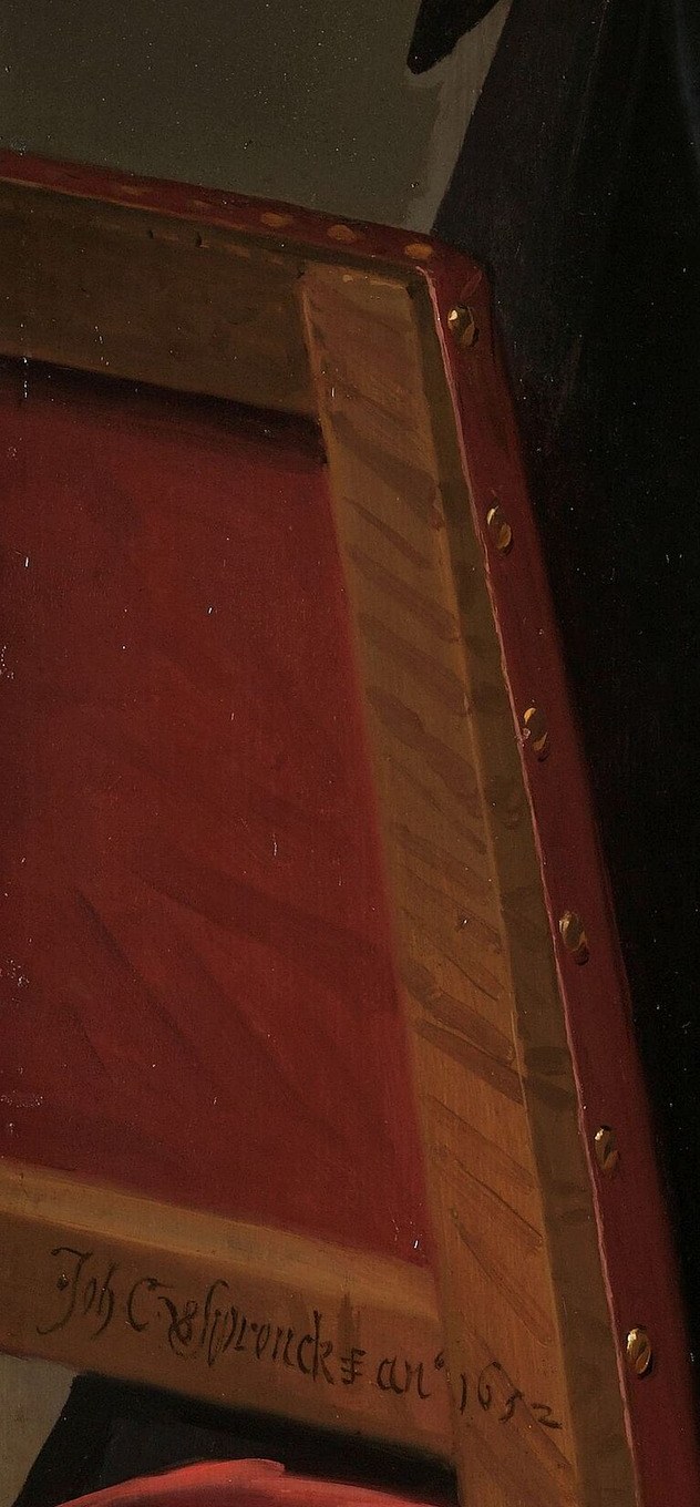 Look closely at the armrest of his red chair.
