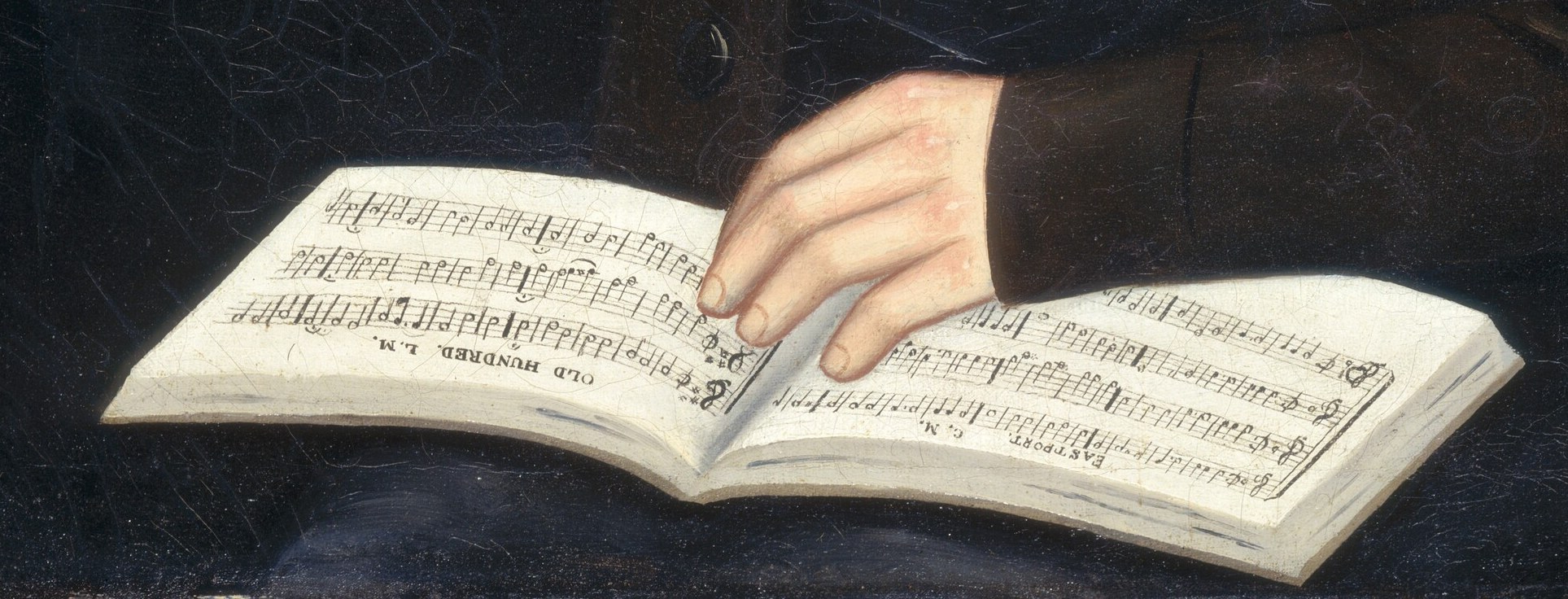 He holds an open tune book, a sign of cultivation.