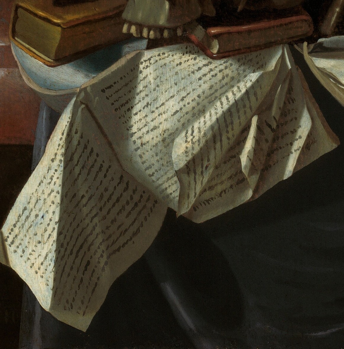 The text suggests human knowledge and endeavor, contrasting with the skull and emphasizing the vanity of earthly pursuits.