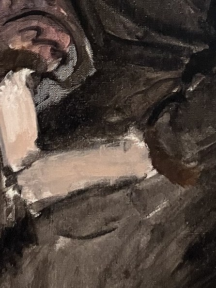 The way her hands are clasped suggests a moment of quiet contemplation or perhaps a subtle tension.