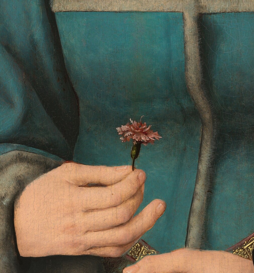 Her left hand rests on a well-worn prayer book.