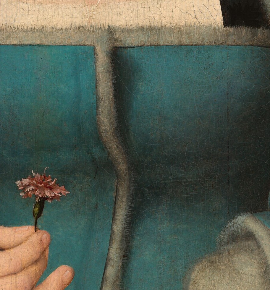 The carnation she holds meant betrothal, and also the Passion.