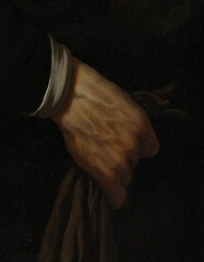 But his left hand holds a peculiar folded cloth.