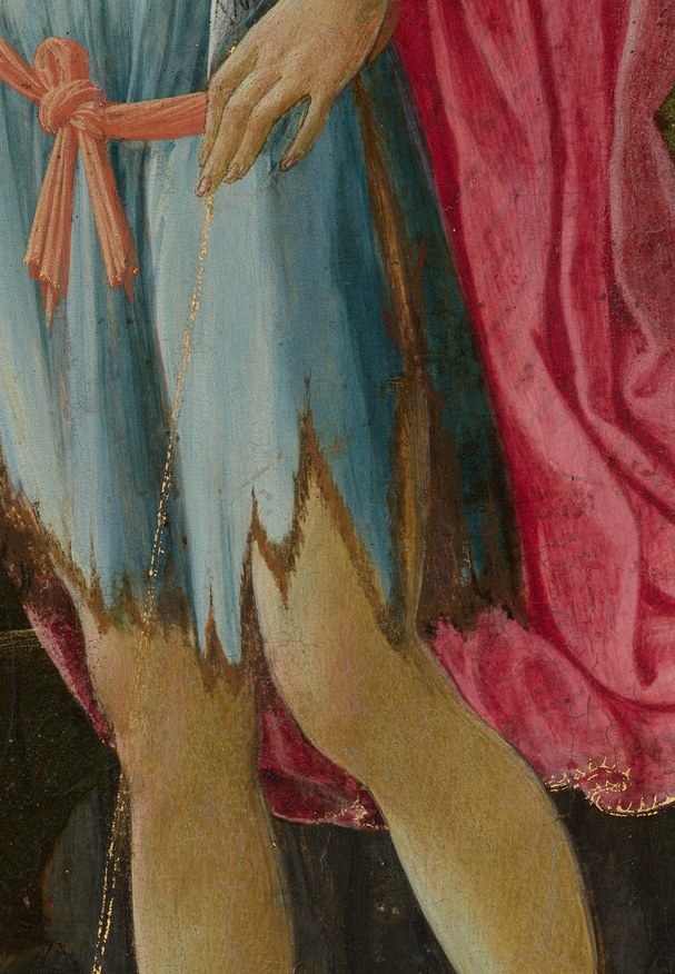 His left holds a reed cross. You almost miss it against the pink cloak.