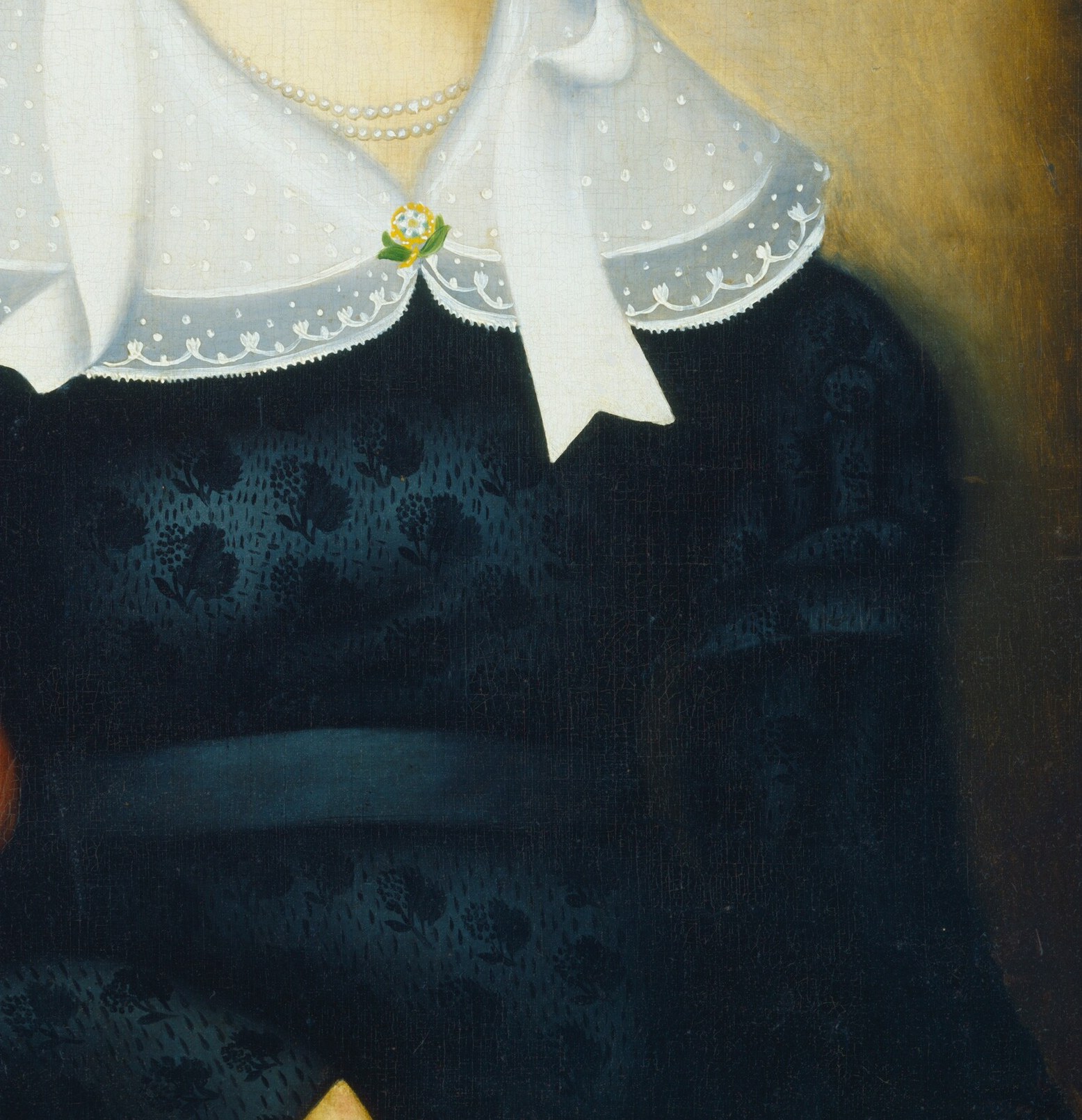 She wears a dark dress, a simple pearl necklace.