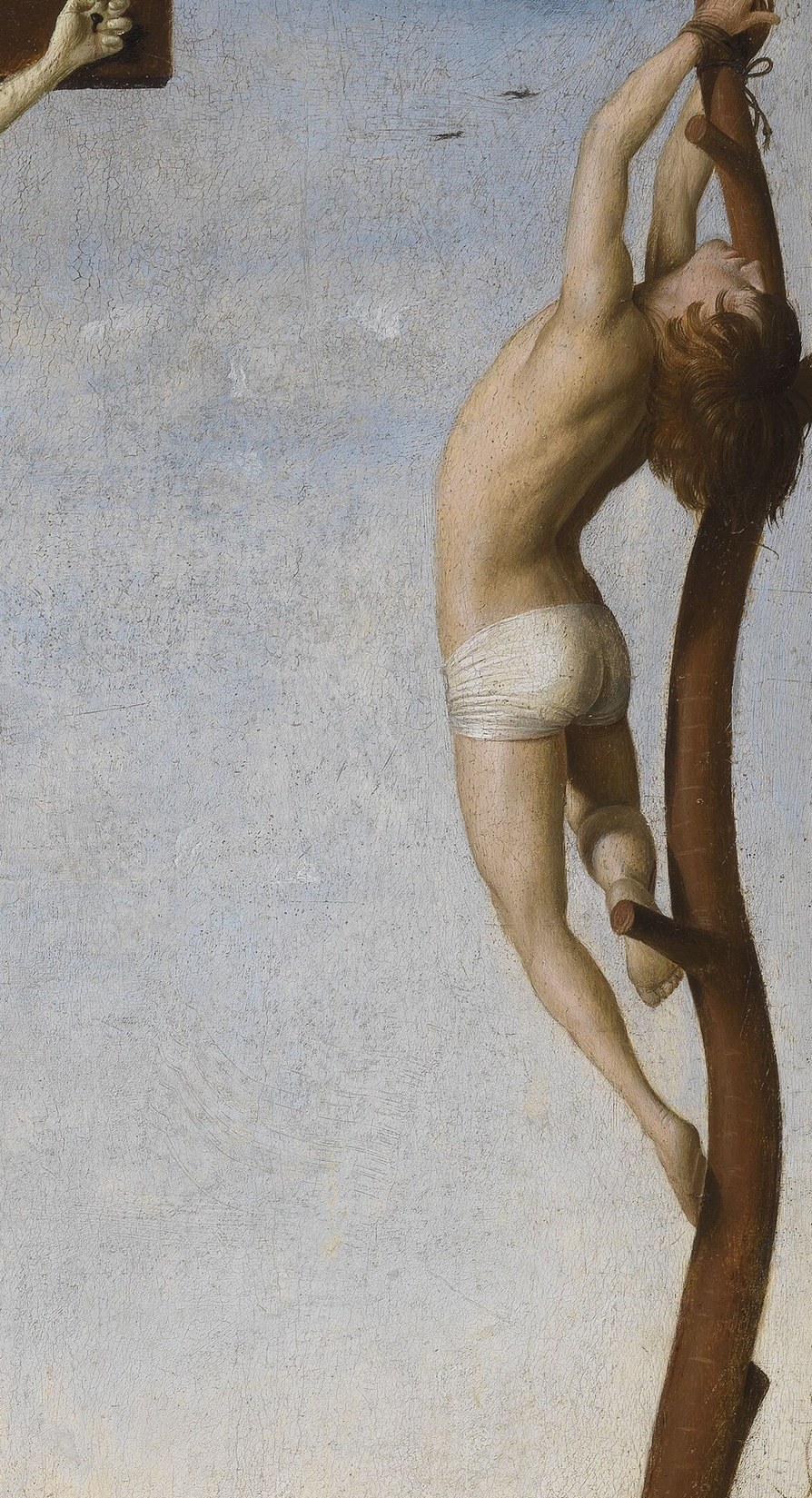 His posture suggests a struggle against his fate, contrasting with the other figures.
