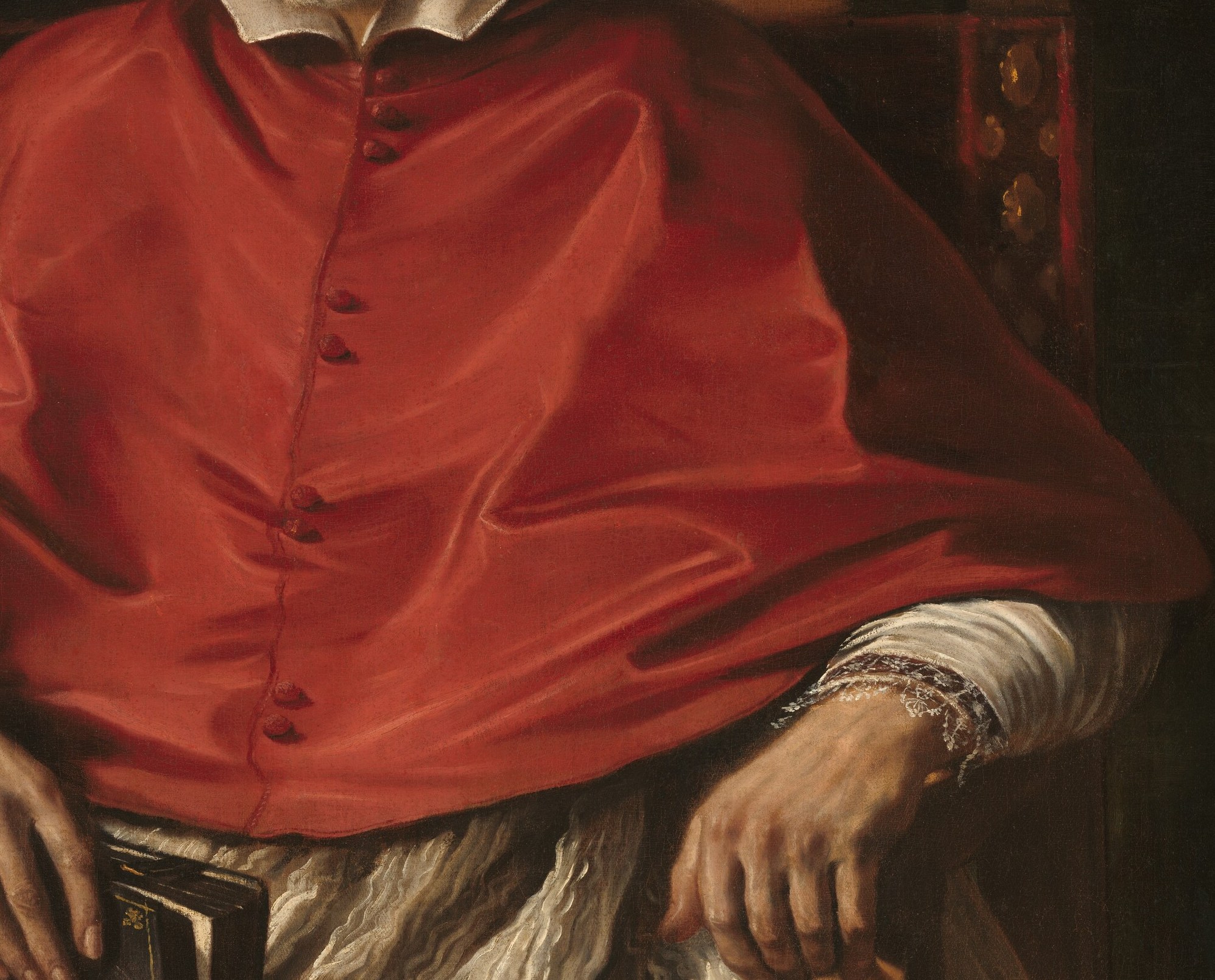 His red biretta and robes signify his high rank.