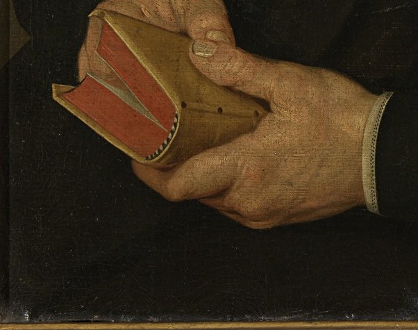 His hands gently hold the pages, a quiet contemplation.