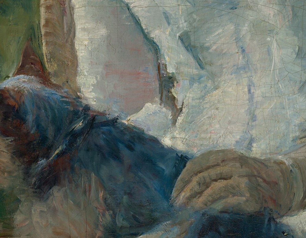 Her hands rest on something warm and dark in her lap.