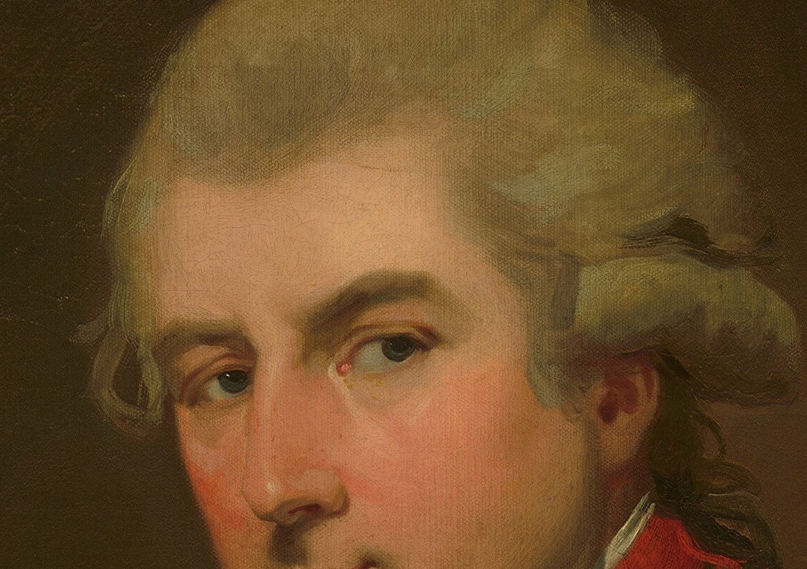 The red collar and powdered wig insist on his rank.