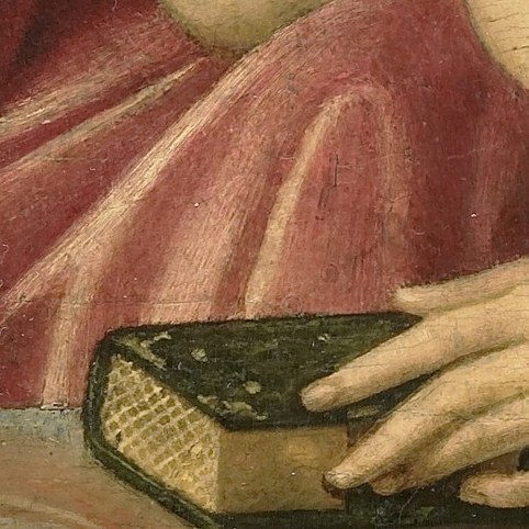 Her hand rests on a book, a symbol of scripture.