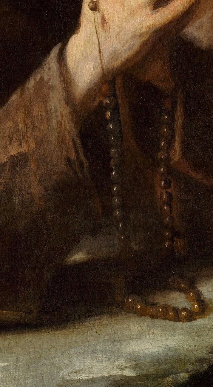Look at the worn rosary beads in his hands.