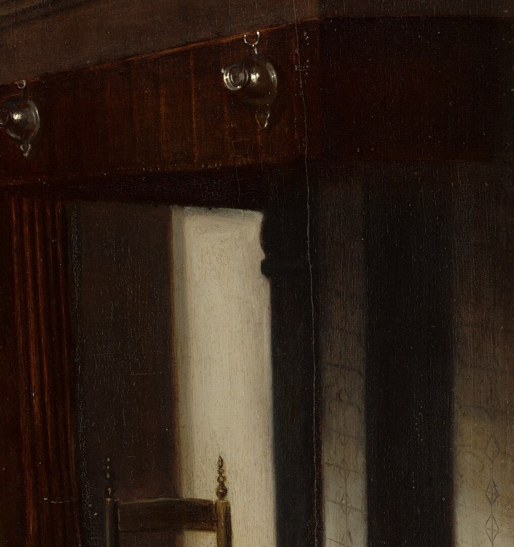 Behind her: an unlit hearth. The house is quiet.