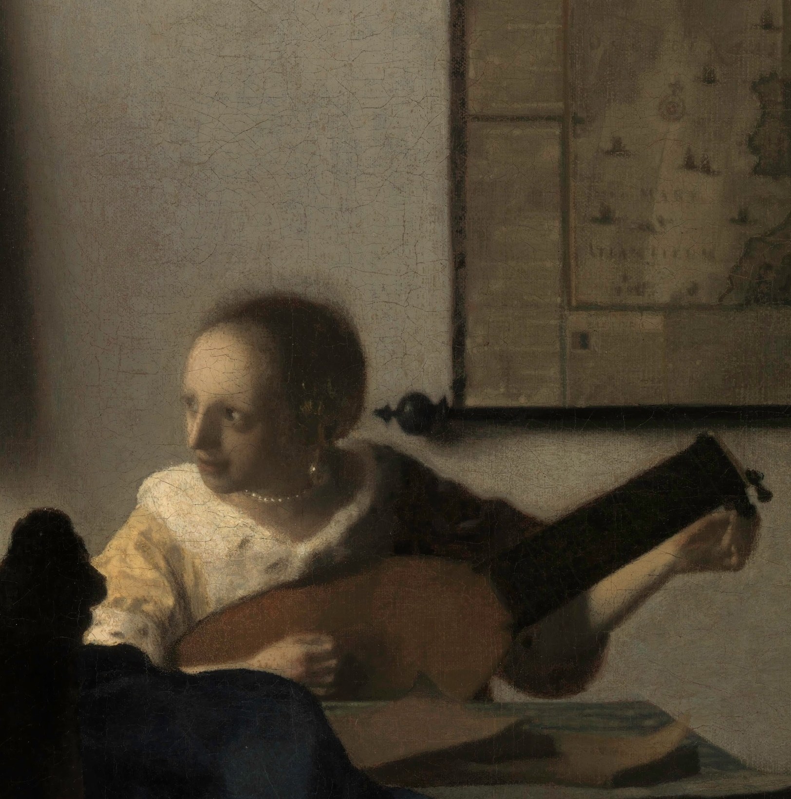 The fur-edged jacket recurs across several Vermeer interiors; painted with subtle impasto it signals comfortable bourgeois wealth and connects this figure to a network of domestic portraits