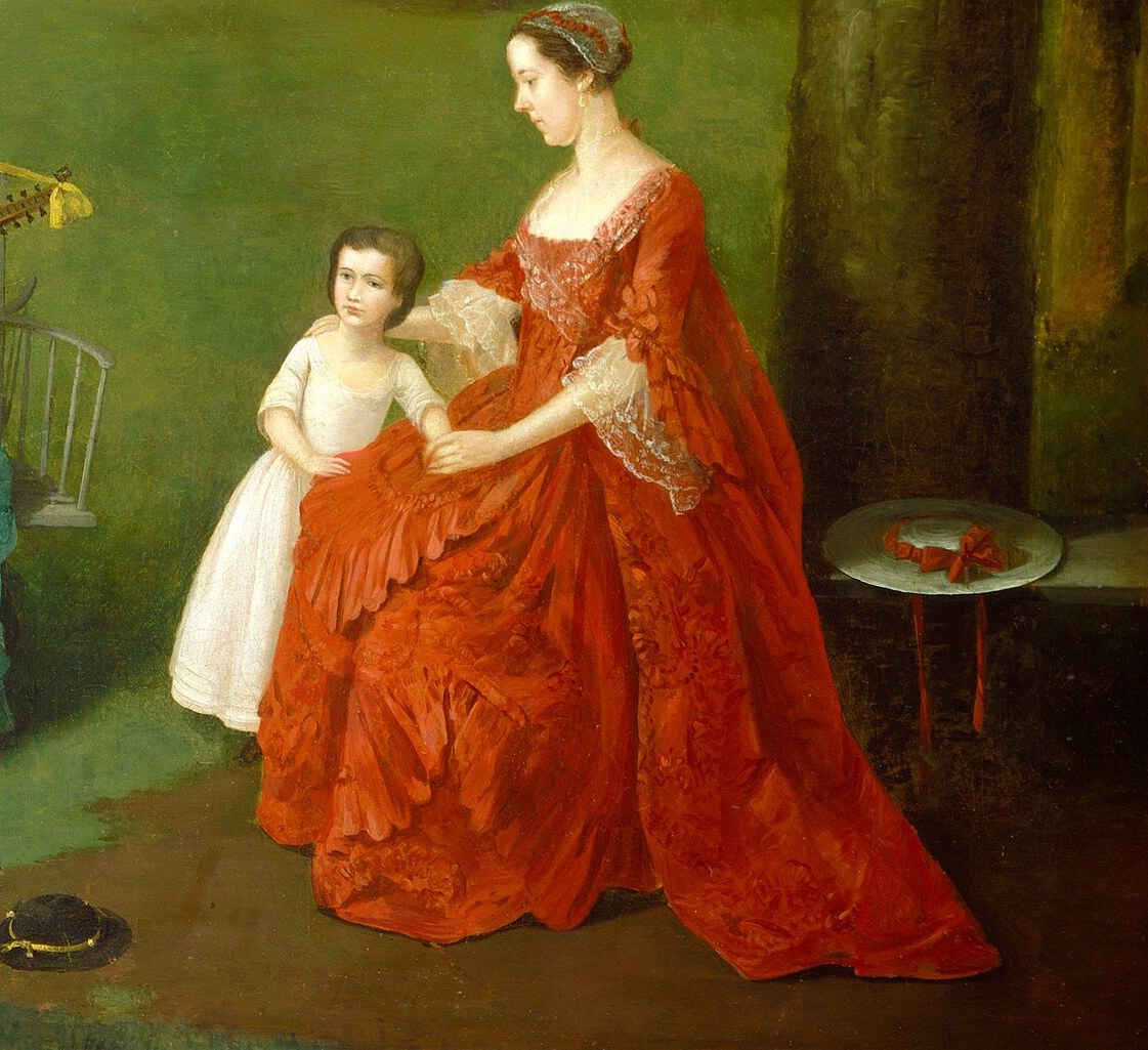 Her elaborate dress and attentive posture indicate social status and maternal care.