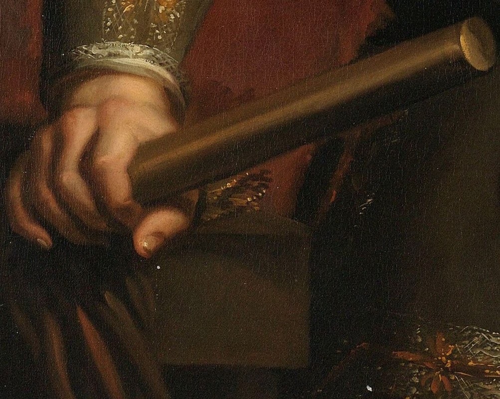 The baton he holds symbolizes his authority.