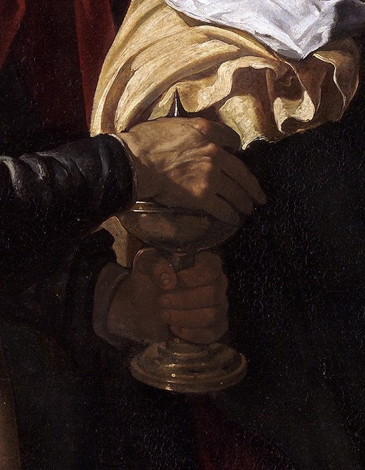 His hands are clasped in prayer.