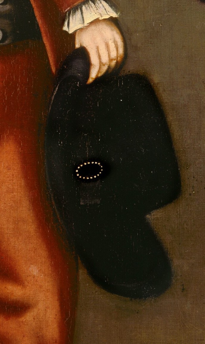 Holding his hat suggests a moment of transition or politeness, and its dark color contrasts with his attire.