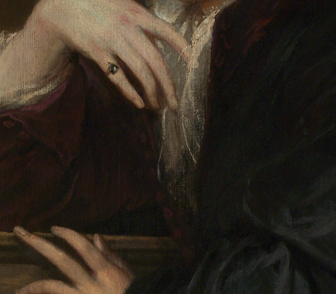 His left hand rests on a stone ledge.