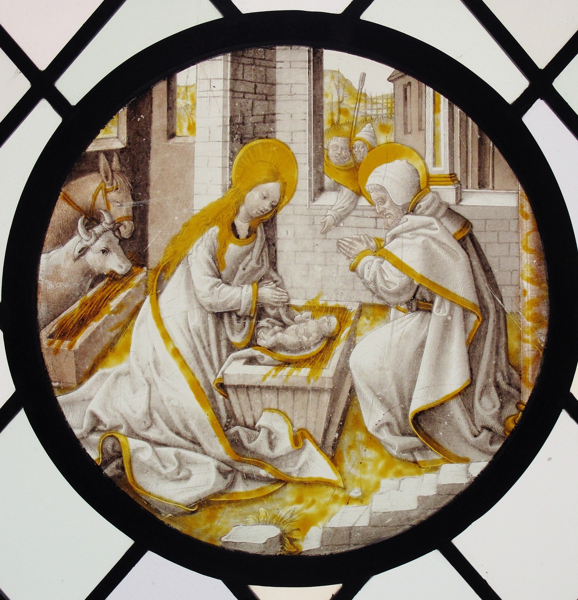 The circular frame is itself the medium's signature: a roundel was designed to be set into a larger glazing scheme, so this perfect circle is a functional and aesthetic choice that condenses the Nativity into a medallion format.