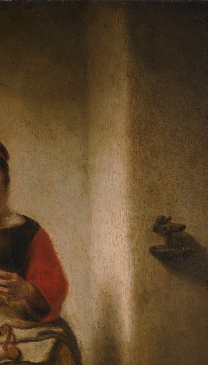 A bare wall washed with warm amber light is Maes's Rembrandtesque signature device , it gives the intimate scene spatial air and makes the figure pop without a window being shown.