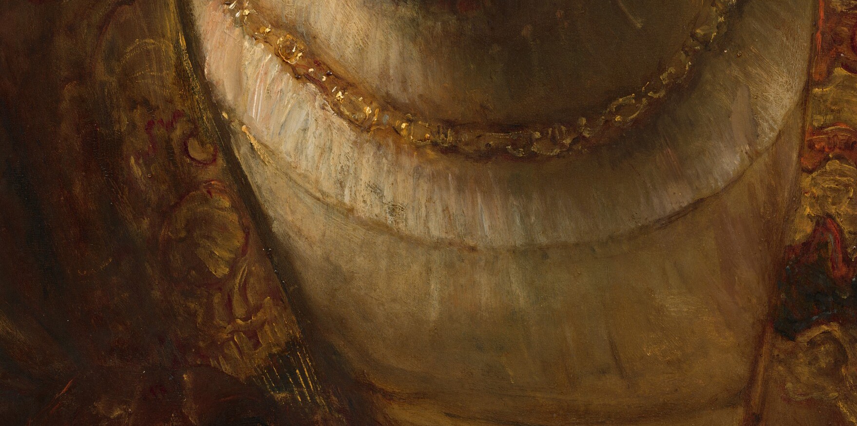 Gold embroidery cuts across the brownish-red wool.
