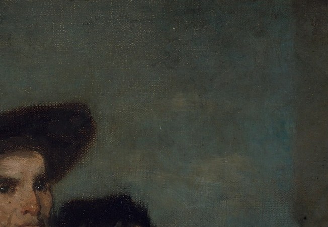The hat silhouettes against an indistinct background and functions as a visual roof over the group, drawing the eye downward into the cluster of faces