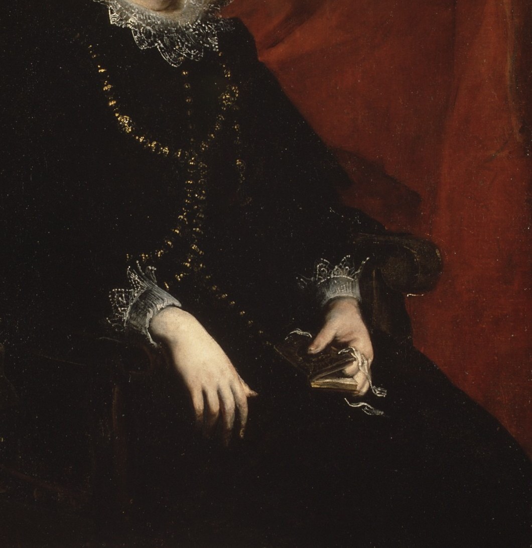 She wears a jeweled necklace and a gold-embroidered dress.