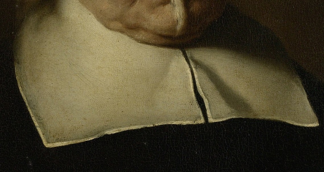 The stark white collar draws attention to his face.