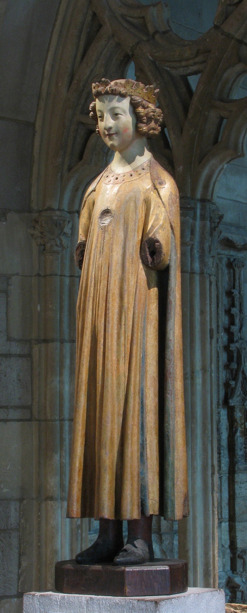 The architectural setting frames the figure, its dark, rough texture contrasting with the king's illuminated presence.