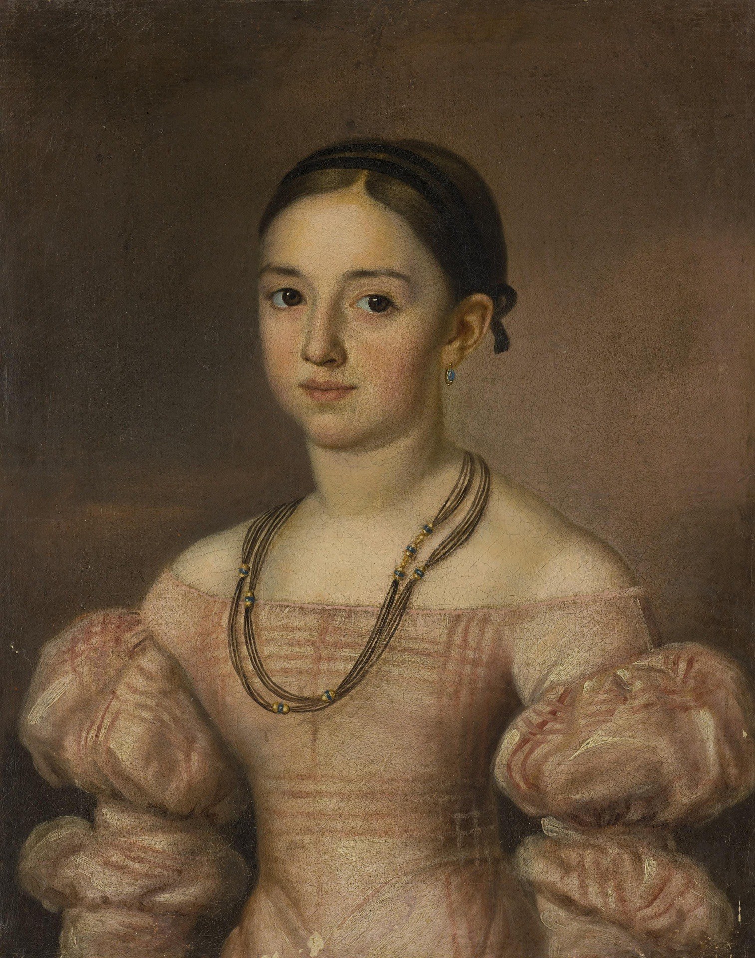 It creates a dramatic contrast, pushing the sitter forward and emphasizing her presence.