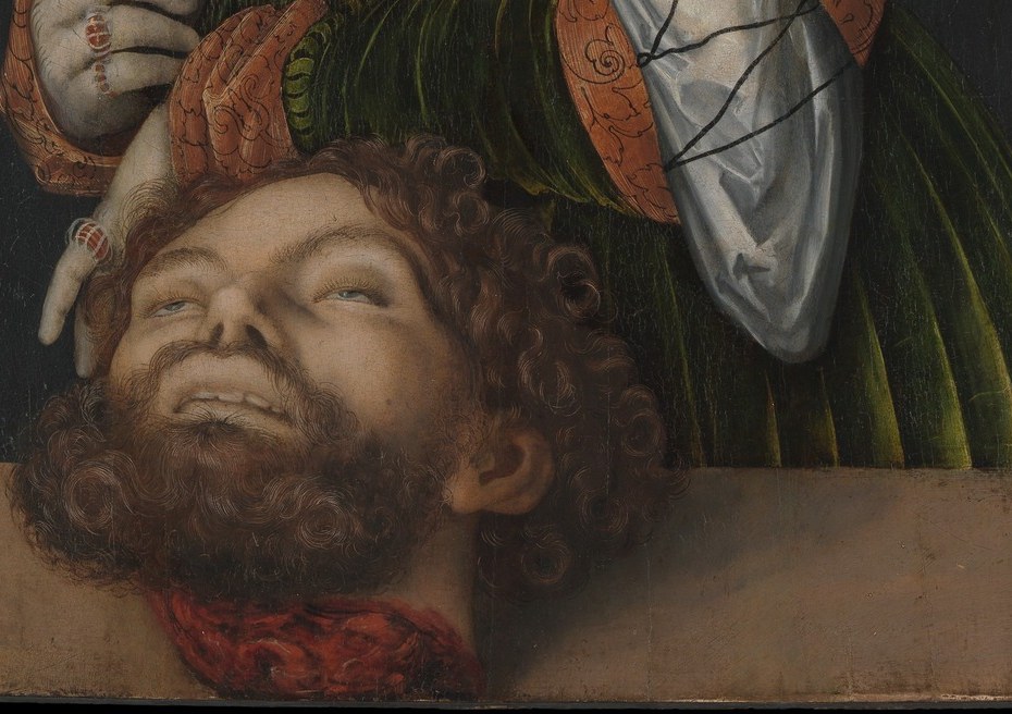 Holofernes' face , eyes half-open, beard matted , is held matter-of-factly at thigh level, as if Judith were carrying a market basket; the casualness amplifies the horror.