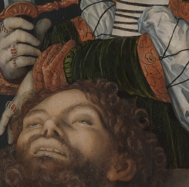 The knuckles, tension of grip, and delicate rings on the fingers create a visceral contrast between feminine adornment and violent action , a favorite Cranach tension.