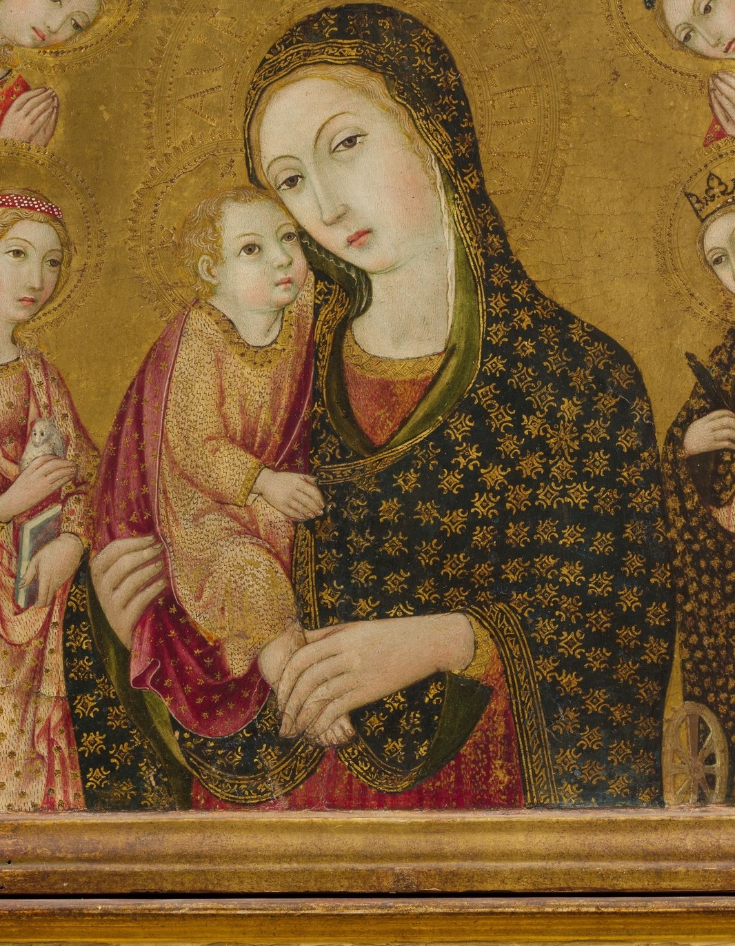 The obsessively regular geometric brocade is a tour de force of tempera brushwork , dozens of tiny gold lozenges applied freehand; this is the painting's primary virtuoso passage.