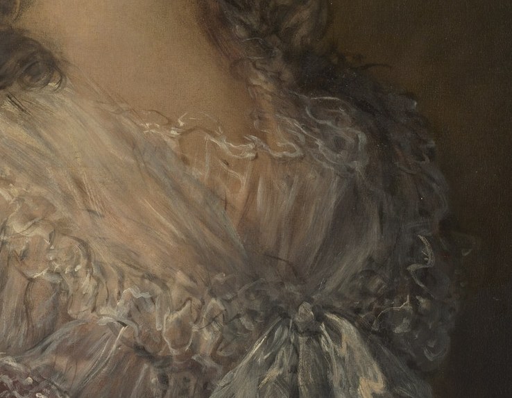 Her dress has a ruffled lace collar.