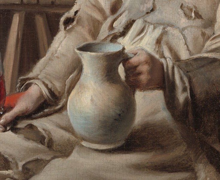 He holds a jug meant for pouring wine.