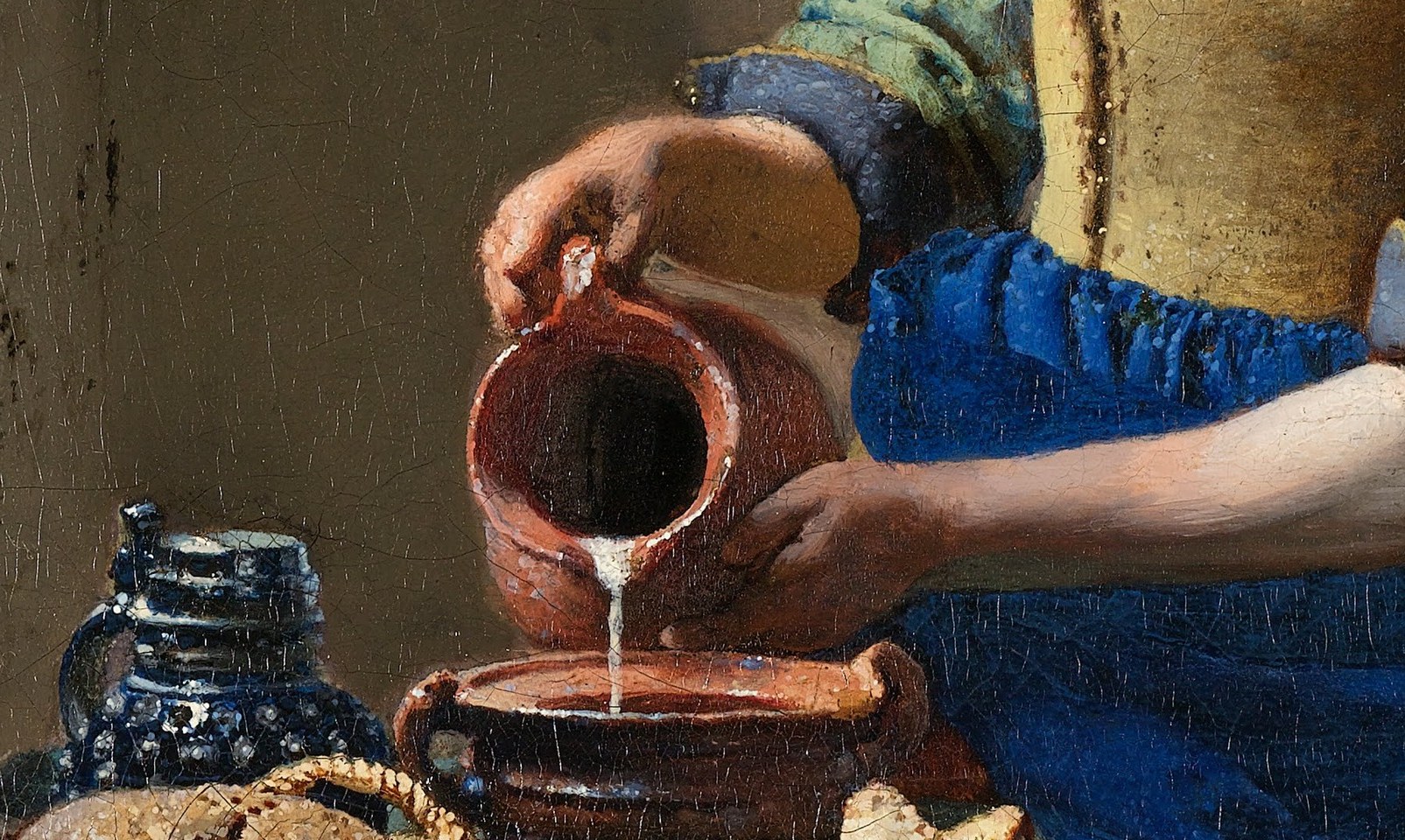 The bread establishes household economy and abundance; the varied crusts and irregular shapes show Vermeer's delight in still-life texture within a genre scene