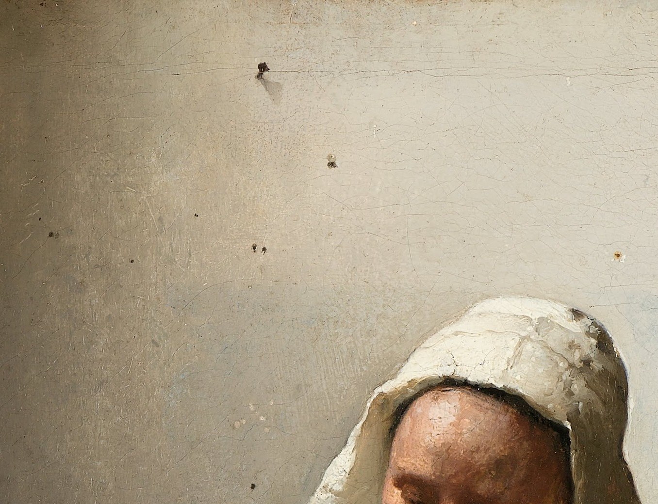 Vermeer's signature move , total absorption in the task, no eye contact with the viewer, which paradoxically draws you in; the white cap glows against the dark wall