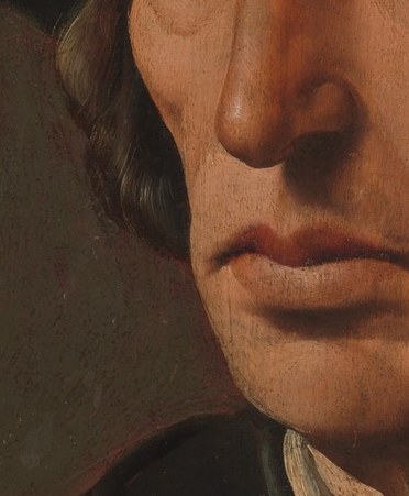 The dark shadow sculpts his face.