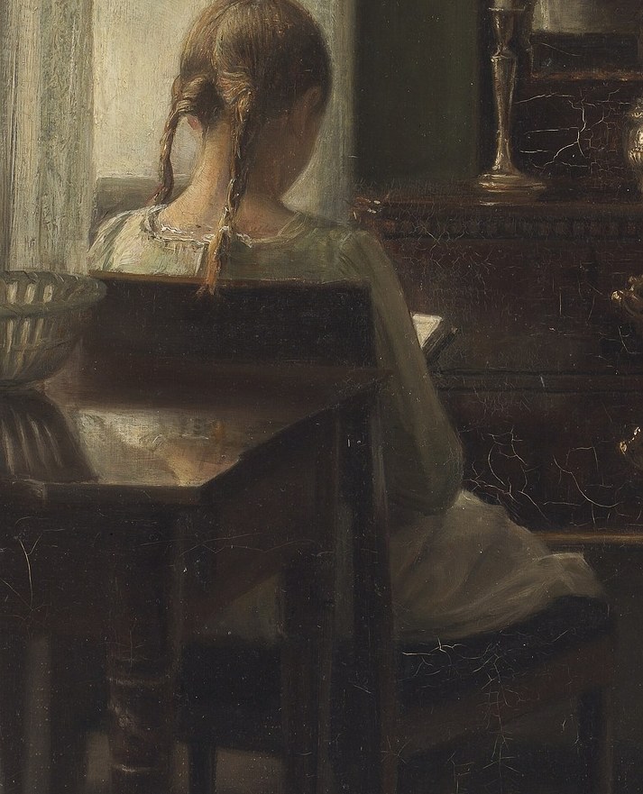 A girl reads by candlelight.