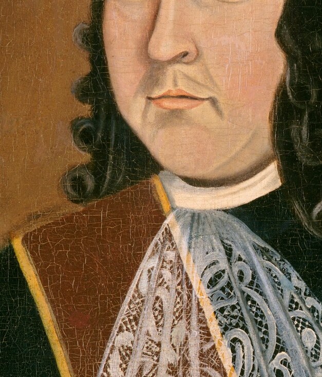 His direct gaze and neutral expression convey a sense of calm authority and self-possession.