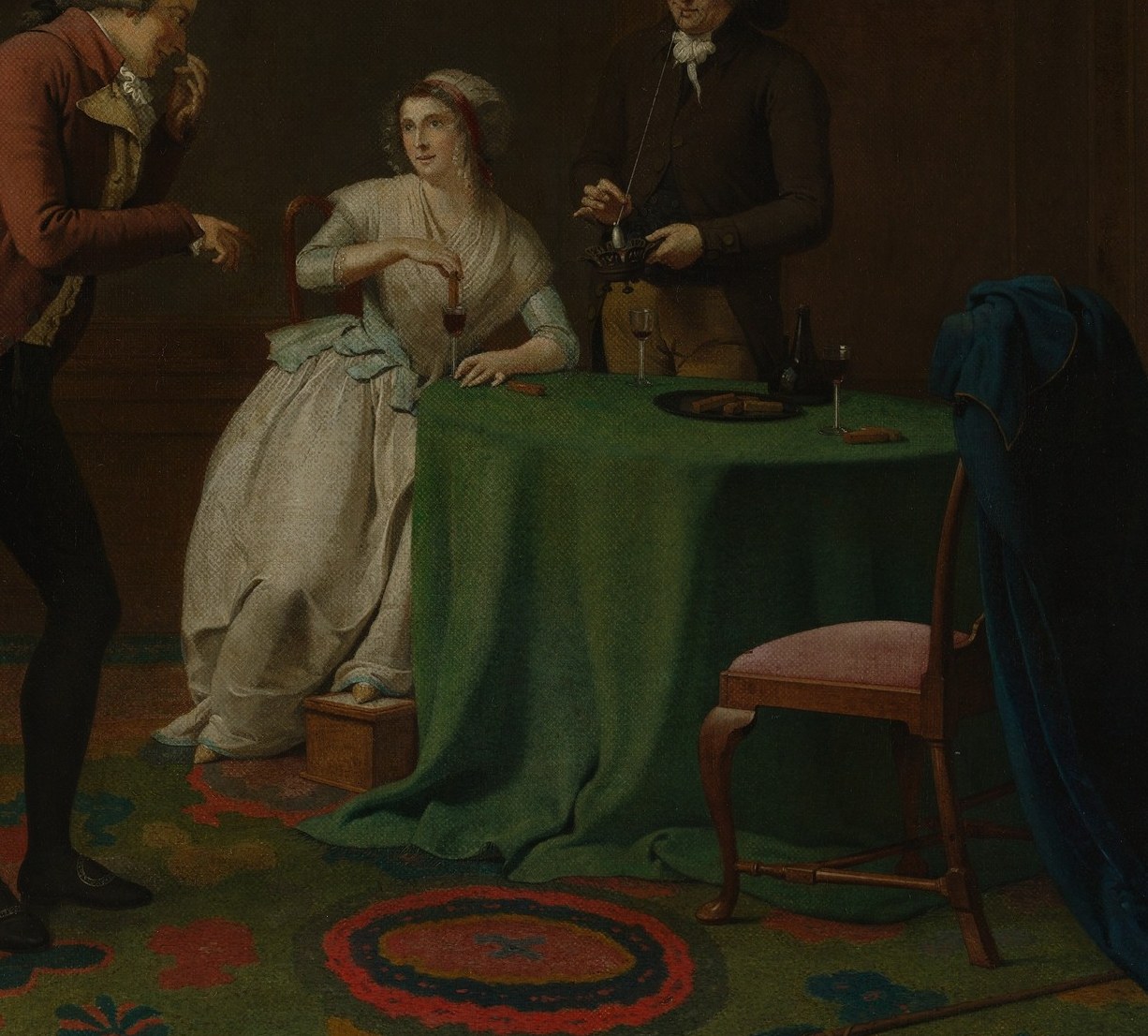 A classic Dutch genre staging device , the draped table as domestic theater platform, organizing figures and holding props in one compositional anchor.