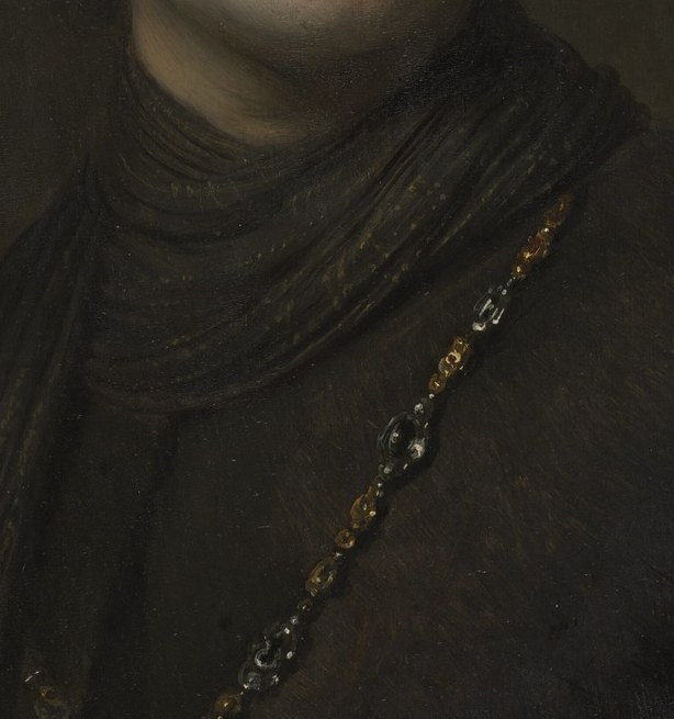 The gold chain across his chest signals rank or patronage.