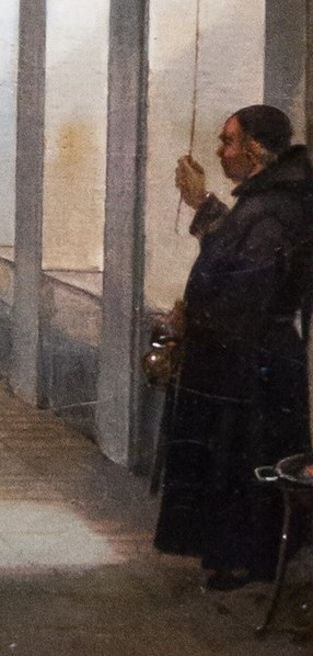 A monk pauses, lost in contemplation before a crucifix.