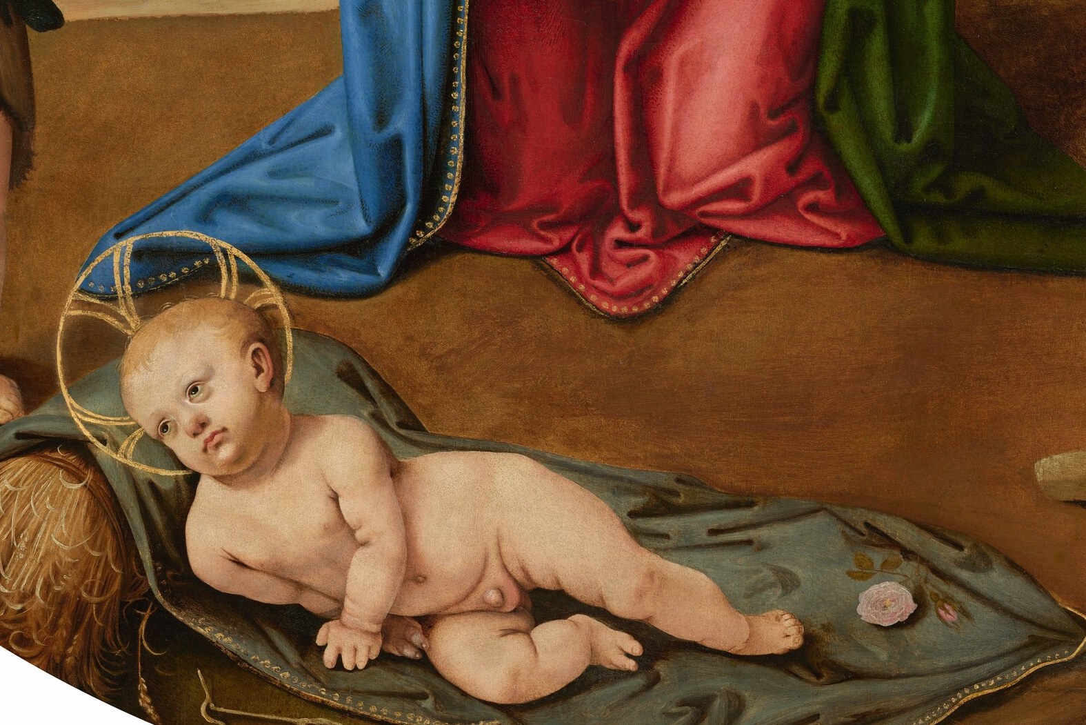 The Christ Child lies on bare earth. Not a manger.