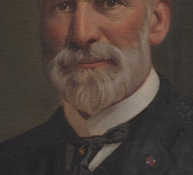 The neatly trimmed beard adds to his distinguished and professional appearance.