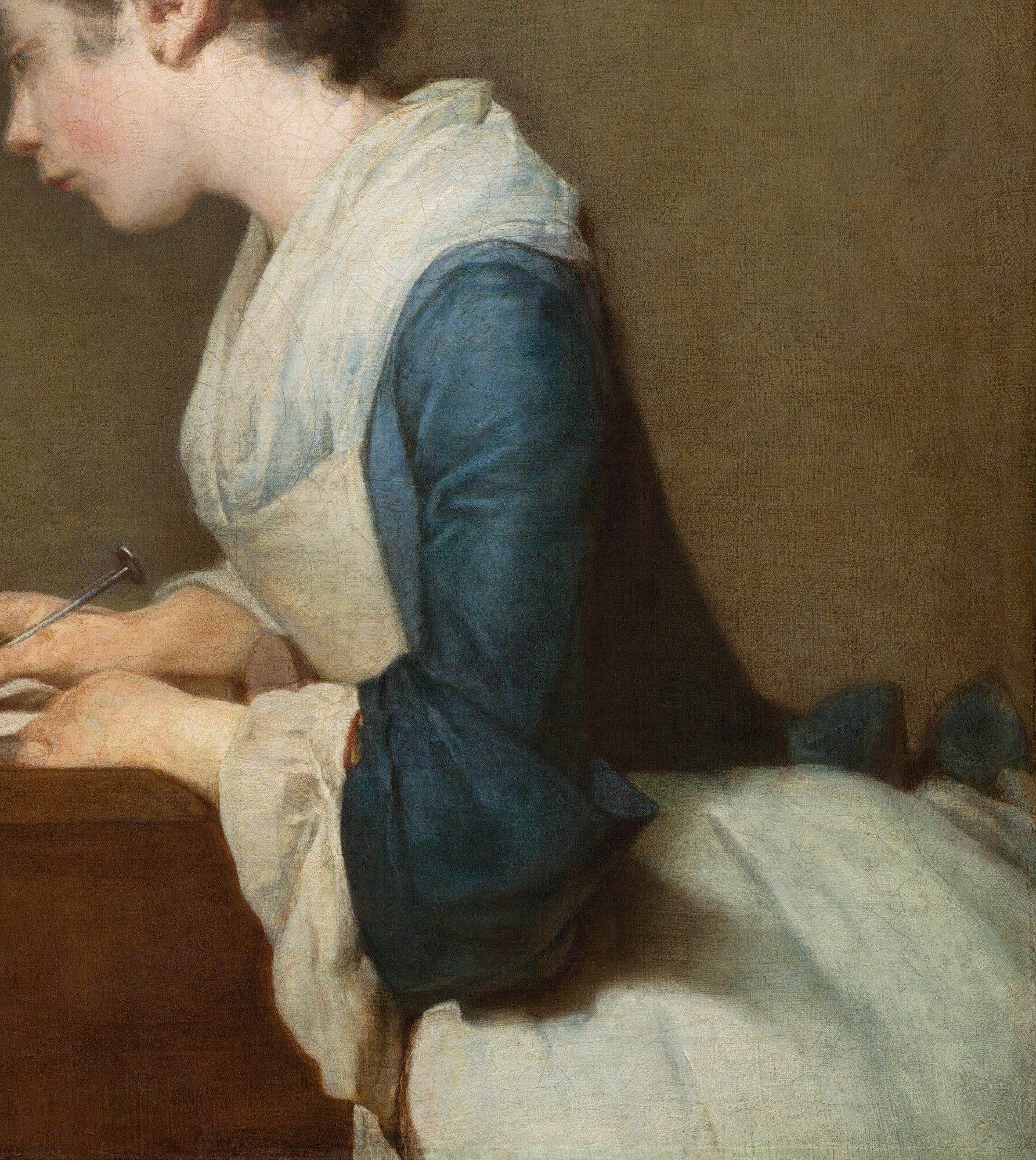 The crisp white fabric and blue sleeve suggest a working-class background and the practicality of her attire.